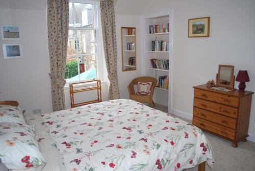 a bedroom with a bed and a dresser and a window at 6 Northgate Vennel, Peebles in Peebles