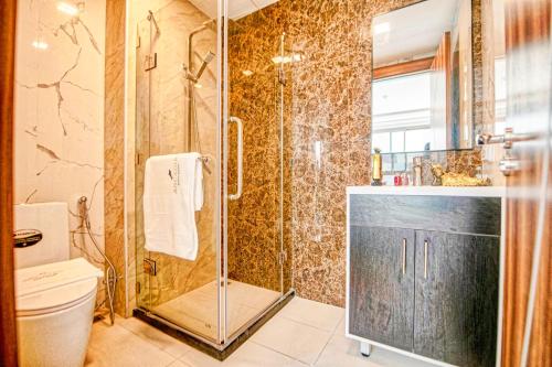 a bathroom with a shower and a toilet at Arcadia Beach Resort Pattaya in Pattaya South