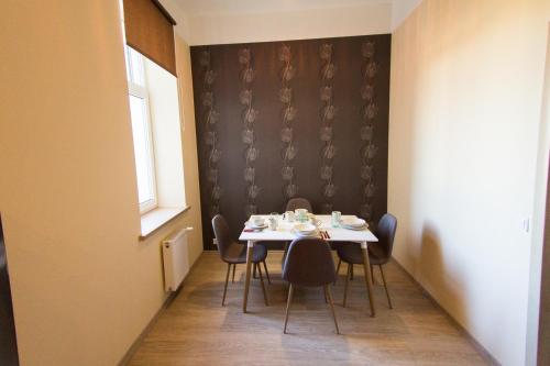 une salle à manger avec une table et des chaises et une fenêtre dans l'établissement Suitu apartments, à Liepāja