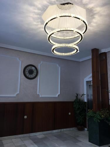 a ceiling with a chandelier and a clock on a wall at Hotel Nacional Melilla in Melilla