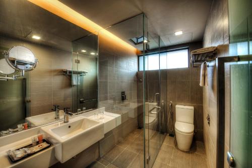 y baño con lavabo, aseo y espejo. en Raia Hotel Kota Kinabalu en Kota Kinabalu