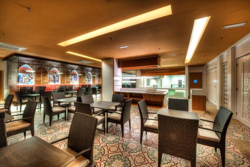 a restaurant with tables and chairs and a bar at Raia Hotel Kota Kinabalu in Kota Kinabalu