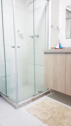 a glass shower in a bathroom with a counter at Beach Class Eco Life Figueira in Porto De Galinhas