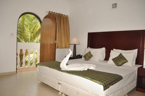 a bedroom with a bed with a white swan on it at Colonia Santa Maria, A Club M Associate in Baga
