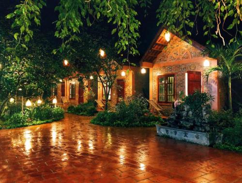 a house with a fountain in front of it at night at Trang An Village Homestay in Ninh Binh