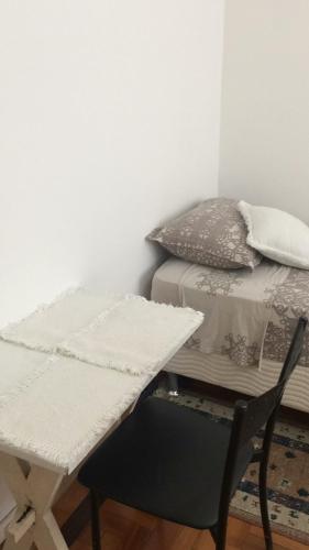 a room with a bed and a table and a chair at Próximo ao Consulado - Quarto Inteiro in Porto Alegre