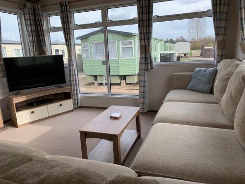 a living room with a couch and a flat screen tv at The Bard's Retreat in Stratford-upon-Avon