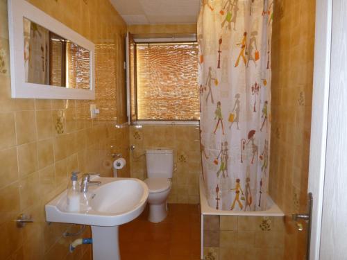 een badkamer met een wastafel, een toilet en een douchegordijn bij Casa Paco in La Galera
