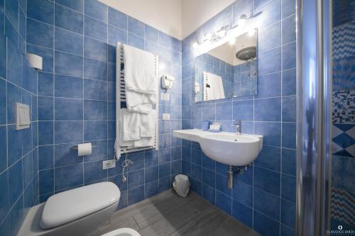 a blue tiled bathroom with a toilet and a sink at L'Approdo Dell'Ammiraglio in La Spezia