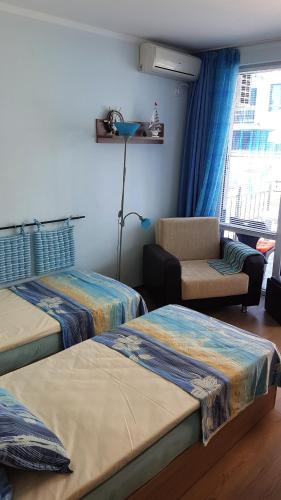 a room with three beds and a couch and a window at Blue Bay Sea View in Pomorie