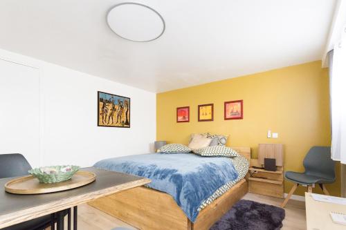 Un dormitorio con una cama y una mesa y sillas. en Entre ville et campagne, en Athis-Mons