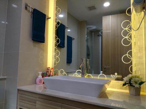 a bathroom with a sink and a large mirror at The Riviera Wongamat Hong Apartment in Pattaya North