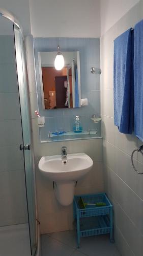 uma casa de banho com um lavatório e um espelho em Blue Bay Sea View em Pomorie