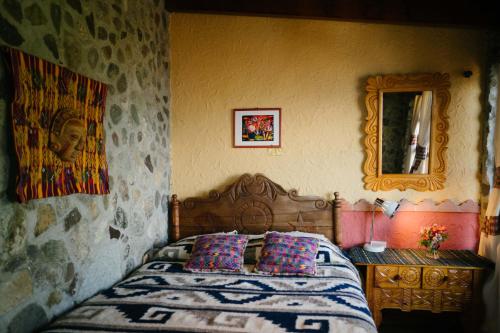 a bedroom with a bed and a dresser and a mirror at Hotel La Casa del Mundo in Jaibalito