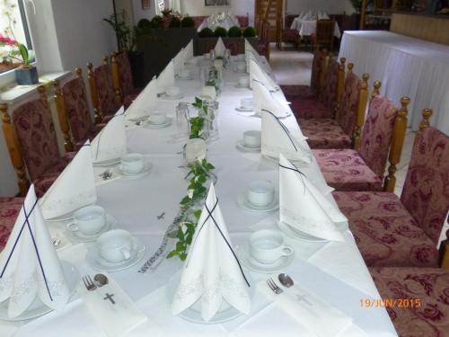 a long table with white tablecloths and napkins at Hotel/Restaurant Balkan in Sömmerda