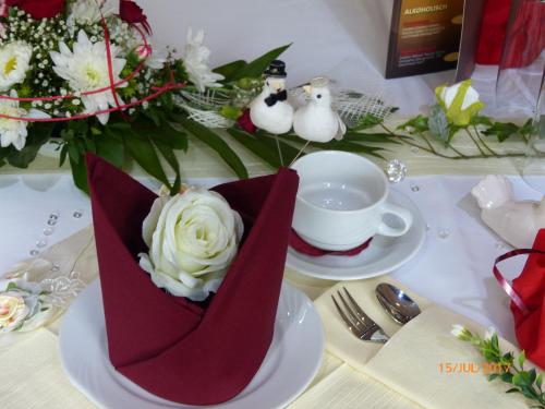 a vase filled with white flowers on a table at Hotel/Restaurant Balkan in Sömmerda
