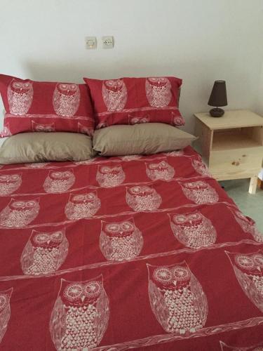 a bedroom with a bed with a red and white bedspread at Chouetterie in Saint-Dizier-Leyrenne