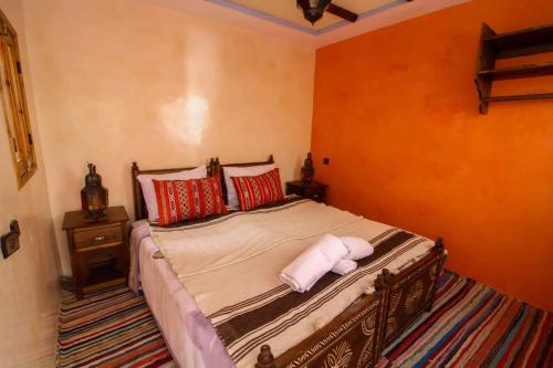 a bedroom with a large bed with red pillows at Berber Family Lodge in Imlil