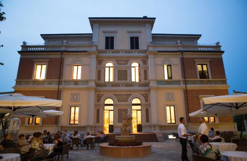a large building with people sitting in front of it at Hotel Villa Borghesi in Corte dei Cortesi