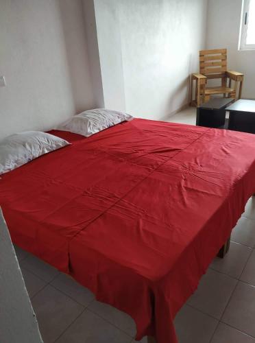 a bed with a red blanket on top of it at Domus Guesthouse in Santana