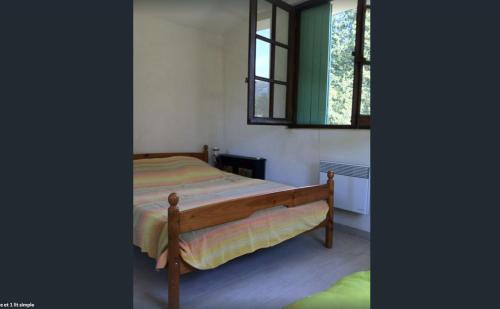 um quarto com uma cama de madeira e uma janela em Mas Ferrieres Saint Laurent em Saint-Laurent-le-Minier