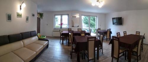 un restaurante con mesas y sillas y un sofá en Pokoje na Wiejskiej, en Nałęczów