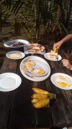 a table with plates of breakfast food on it at By The C' Cabanas in Hikkaduwa