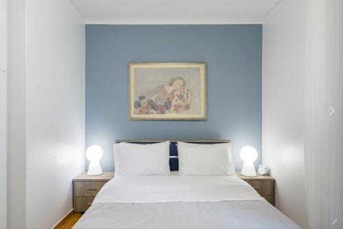 a bedroom with a bed with a blue wall at Athenian Riviera Beach Apartment in Athens