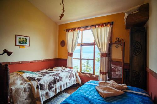 a bedroom with two beds and a window at Hotel La Casa del Mundo in Jaibalito