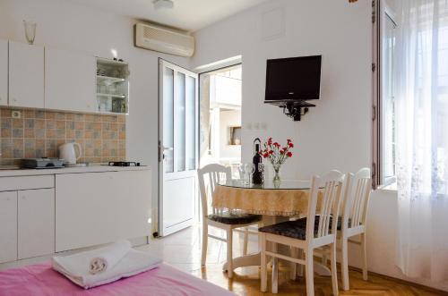 a kitchen with a table and chairs in a kitchen at Apartmani Marko in Makarska