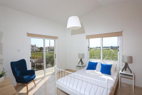 um quarto com uma cama e uma cadeira azul em SeaBreeze Villas by TrulyCyprus em Agia Napa