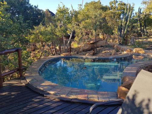 a swimming pool on a wooden deck with a wooden deck at Bona Kgole Private Game Lodge, Mabalingwe in Warmbaths