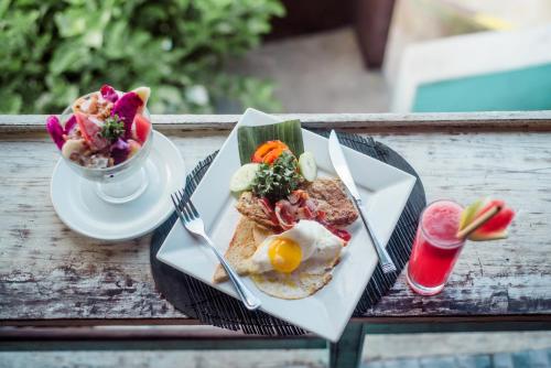 einen Tisch mit einem Teller Essen und einer Schale Obst in der Unterkunft Mamamia Island Villa in Nusa Lembongan