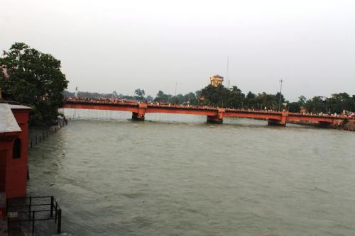 a bridge over a river with people on it at Patnimal Guesthouse in Haridwār