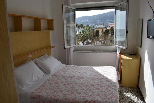 a small bedroom with a bed and a window at Hotel Garden in Marina dʼAndora