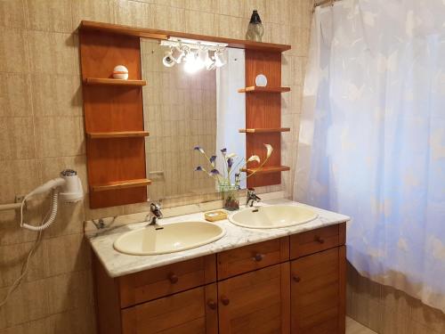 a bathroom with two sinks and a mirror at Vivenda do Paúl in Geres