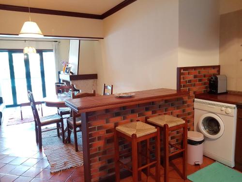 a kitchen with a brick counter with a washing machine at Vivenda do Paúl in Geres