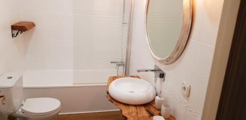 une salle de bain avec un lavabo blanc et un miroir dans l'établissement Domus Valencia Apartamentos centro frente a Torres de Serrano, à Valence