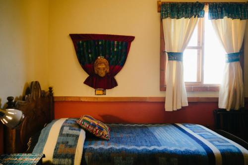 a bedroom with a bed with a mask on the wall at Hotel La Casa del Mundo in Jaibalito