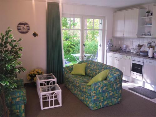 ein Wohnzimmer mit Couch und Küche in der Unterkunft Eine schöne 3-Zimmer-Wohnung mit Ostsee-Zugang! in Juliusruh