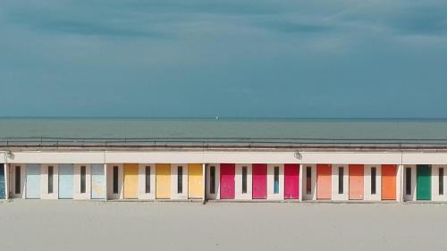 um edifício com diferentes janelas coloridas na praia em Le Metz, Duplex, 2 Chambres em Le Touquet-Paris-Plage