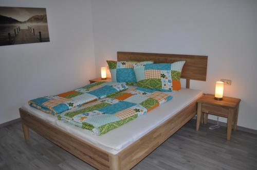a bedroom with a bed with a quilt and two lamps at Ferienwohnung Rudigier Elke in Silbertal