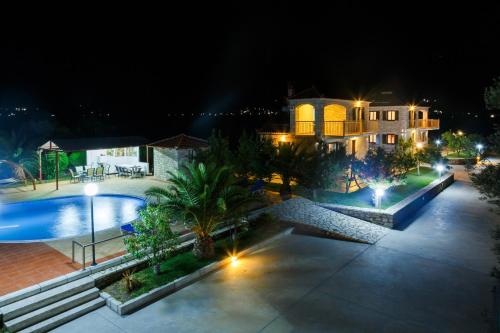 an aerial view of a swimming pool at night at Glyfada Villas || in Paralion astros