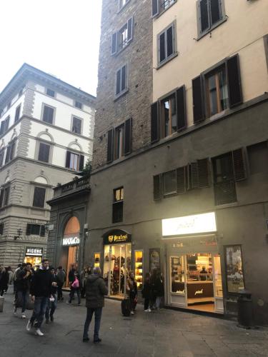 a group of people walking down a street next to buildings at Appartamento Duomo in Florence