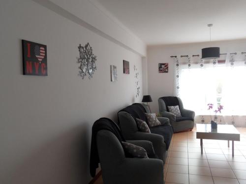 a living room with two couches and a table at Appartement de standing in Nazaré
