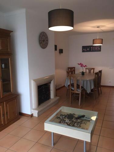 a living room with a table and a fireplace at Appartement de standing in Nazaré