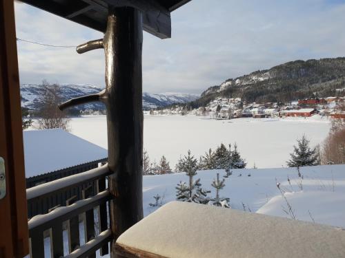a view from a porch with a view of a snow covered lake at Nedre Strand Hytteutleie in Vradal