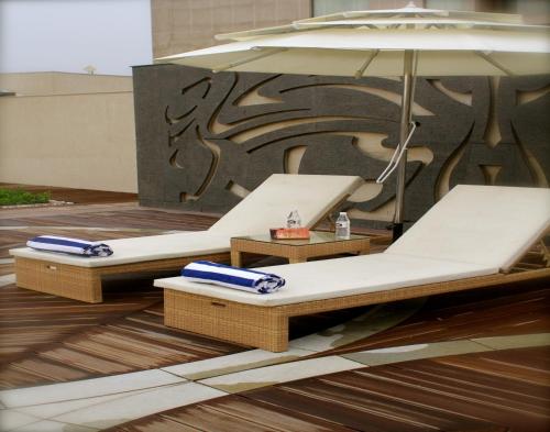 two beds with umbrellas on the floor of a building at Savoy Suites Manesar in Gurgaon