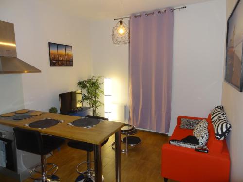 un salon avec une table et une chaise rouge dans l'établissement Appartement GOOD MINDSET, à Avignon
