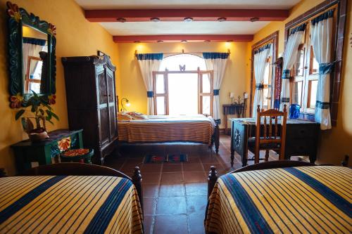 a bedroom with two beds and a window at Hotel La Casa del Mundo in Jaibalito